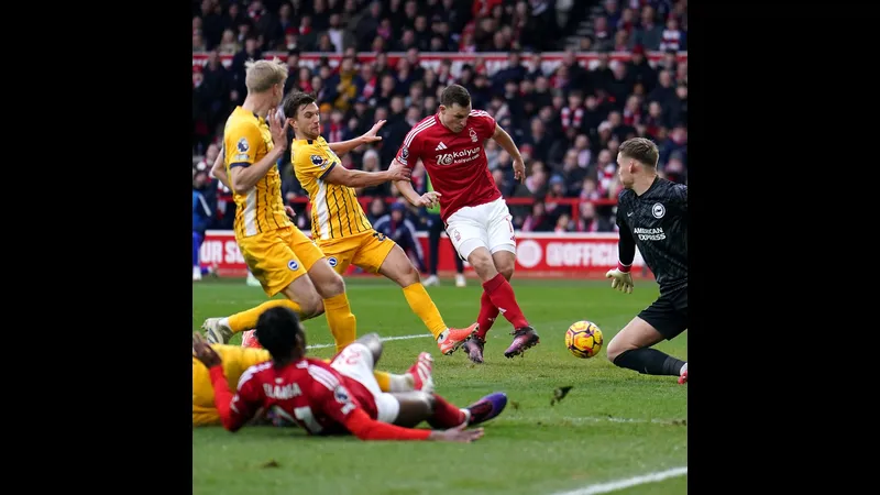 Cầu thủ của Nottingham Forest chạy nhanh với bóng trước áp lực từ cầu thủ của Brighton